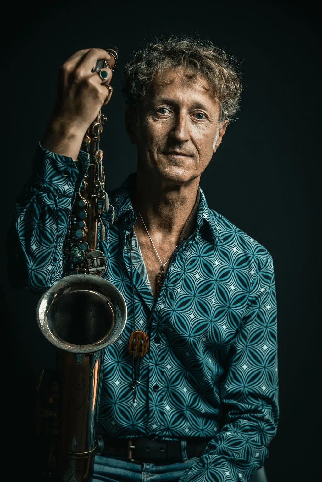 Musiker Stephan-Max Wirth mit Saxophon im blauen Hemd